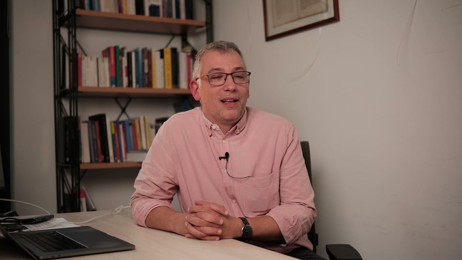 Universität Luxemburg — Standbild aus einem Interviewfilm: Interview im Sitzen in einem Büro mit Bücherregalen