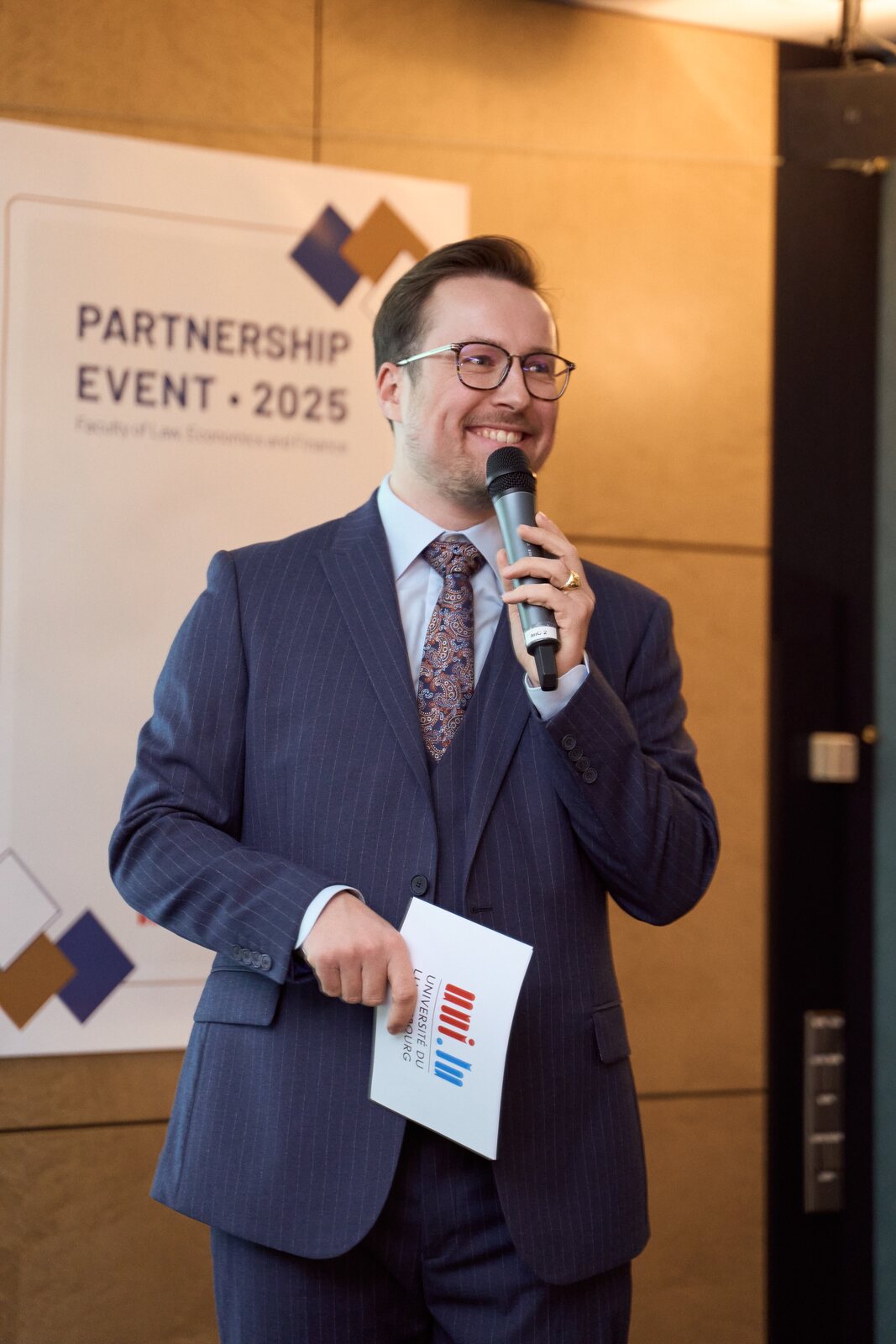 Universität Luxemburg — Moderator mit Mikrofon eröffnet den Abend